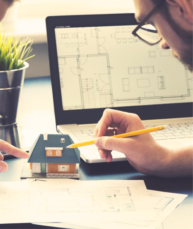 Architect pointing to model house